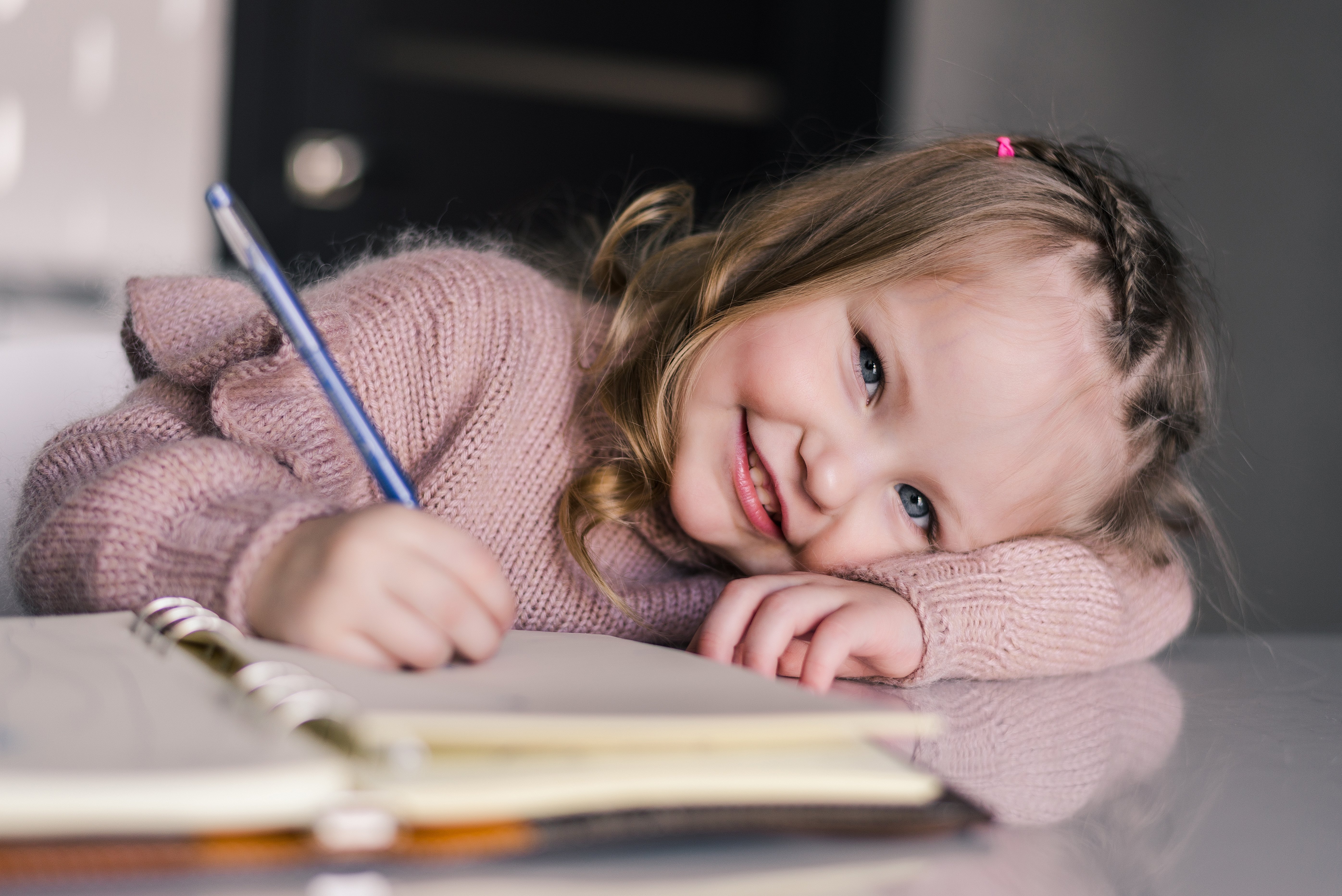 adorable-preschool-girl-drawing-with-pen-table