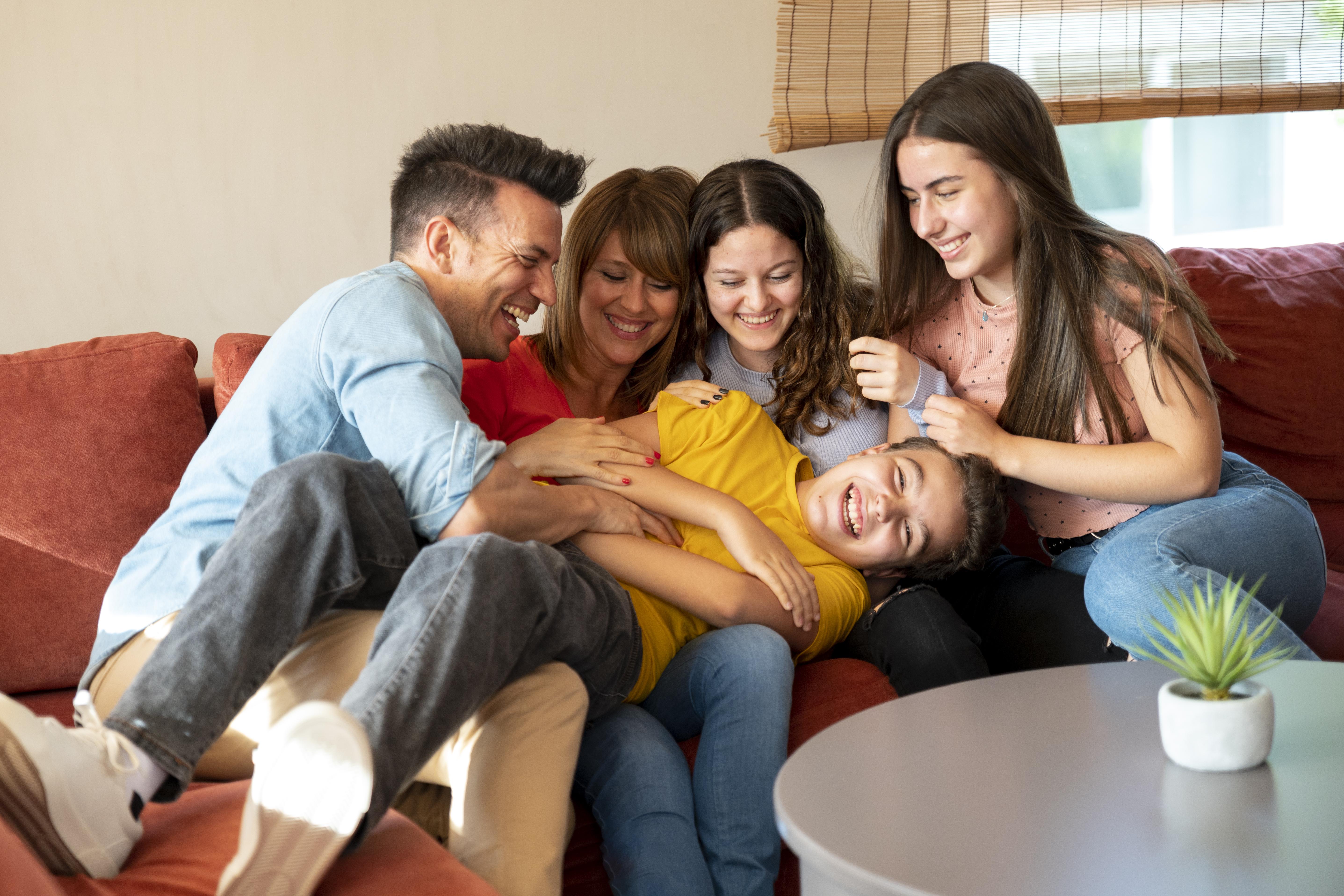 family-with-parents-and-kids-having-fun-on-the-couch-together